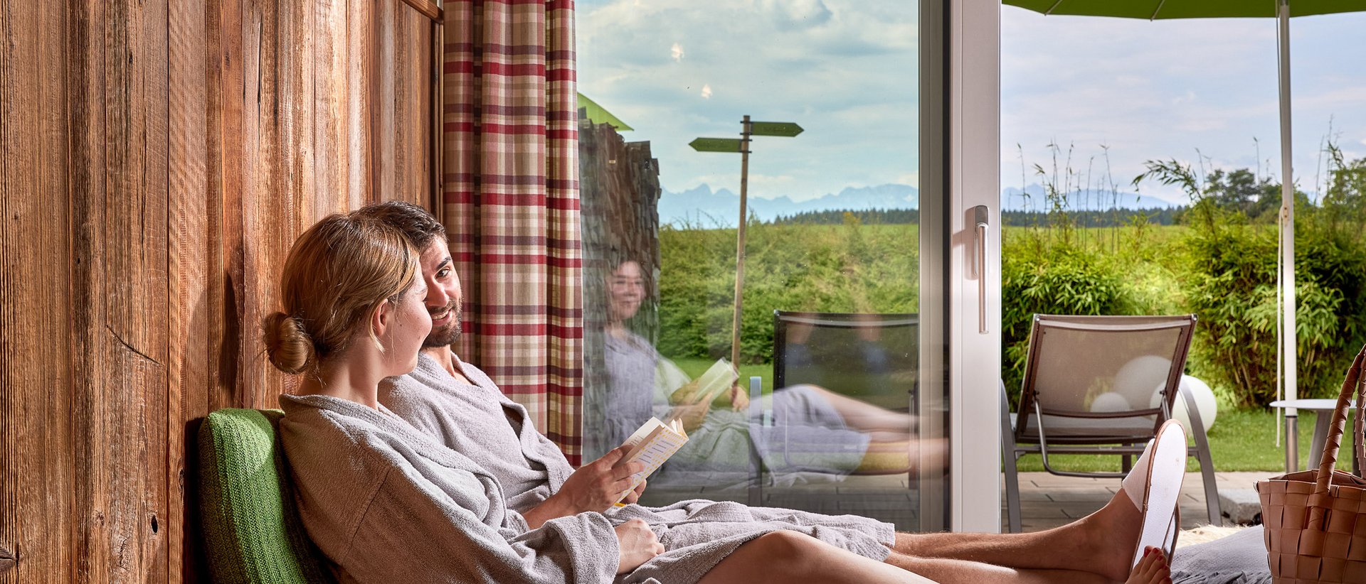 6893 Paar in Bademänteln entspannt sich drinnen mit Blick auf Terrasse und Garten