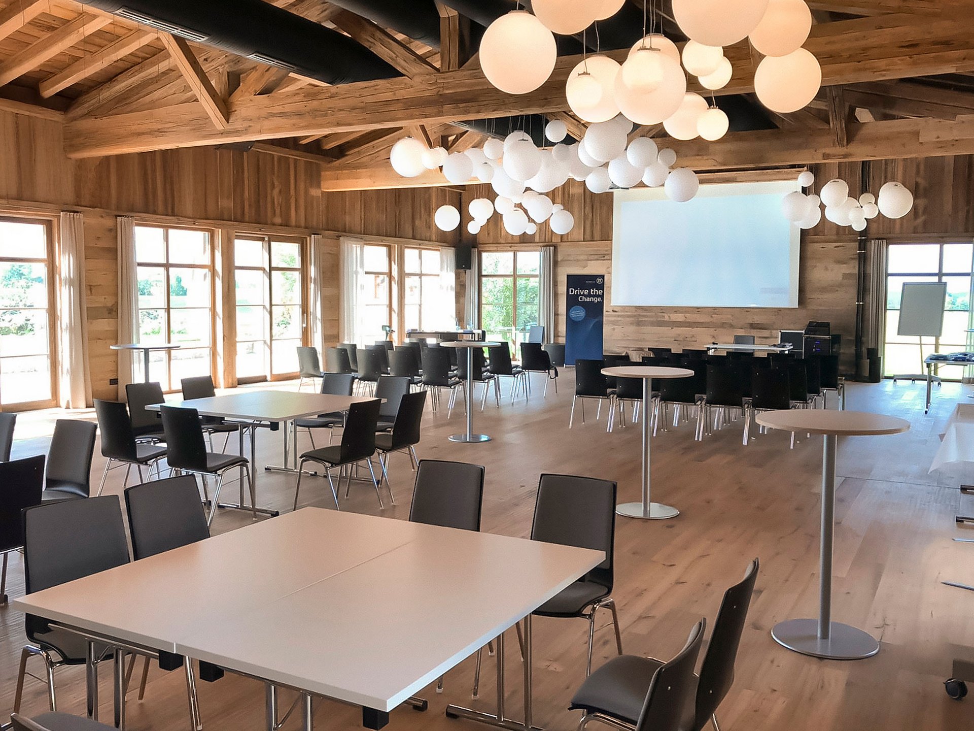 Hotel Das Weitblick Allgäu | Tagungshotel Großer Konferenzraum mit Holzwänden, weißen Tischen und schwarzen Stühlen